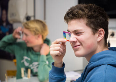 student looking at a light spectrum using a diffraction grating
